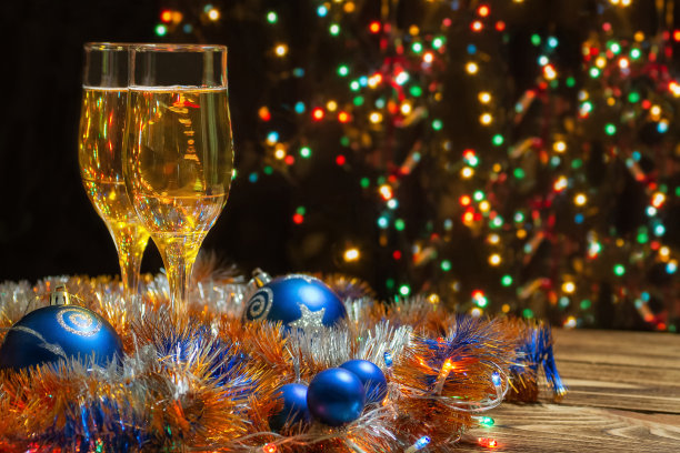 两杯香槟，装饰着一个花环和蓝色的圣诞球，新年的金箔，在一个乡村的背景。新年快乐和2021年圣诞快乐贺卡的概念。放置文本，复制空间图片下载