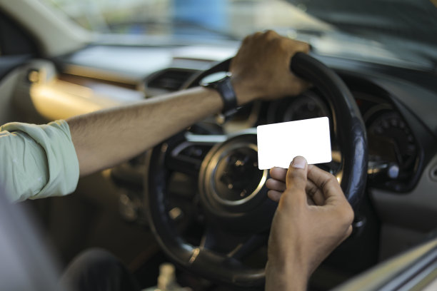 商人在车里展示他的空白名片/信用卡图片下载