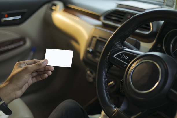 商人在车里展示他的空白名片/信用卡图片下载
