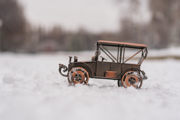 金属模型玩具复古汽车站在雪地上的抽象背景图片下载