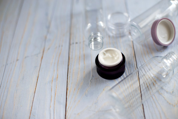 一罐面霜与空瓶子和管洗涤剂清洁剂在自然浅蓝色木制背景图片下载