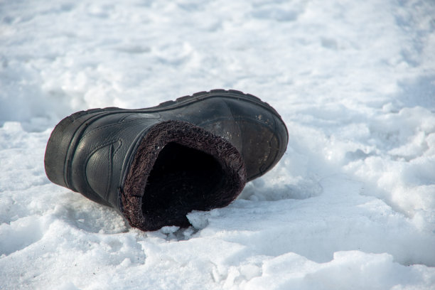 圣诞节节期。旧的破旧的靴子扔在白色的雪地上预示着新娘或新郎将出现的地方图片下载