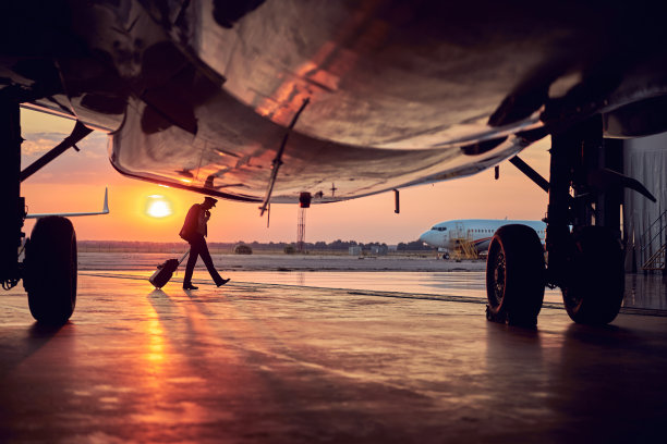 日落时分，飞行员带着行李箱去机场图片下载