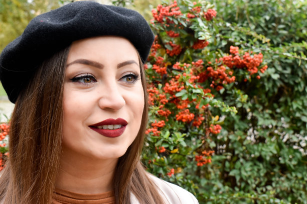 一个在户外戴着黑色贝雷帽的女人的肖像图片下载