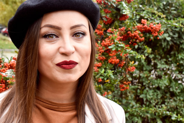 一个女人的肖像戴着黑色贝雷帽在户外的自然图片下载