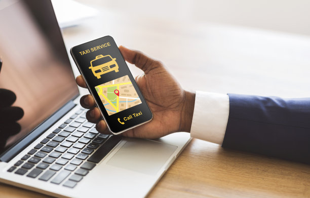 黑人商人拿着带有出租车应用界面的智能手机图片下载