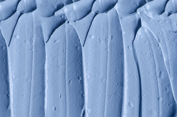 淡蓝色面膜(面膜、面霜、裹体)质地近距离，选择性聚焦。抽象的背景与画笔笔触。图片下载