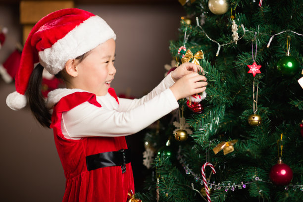 小女孩在家里装饰圣诞树图片下载