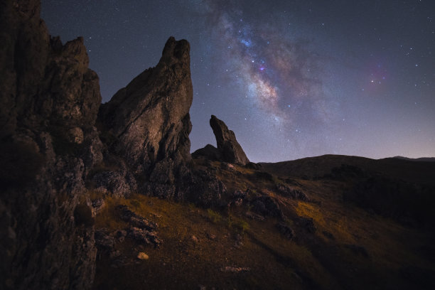 夜景中银河中心的尖顶岩石图片下载