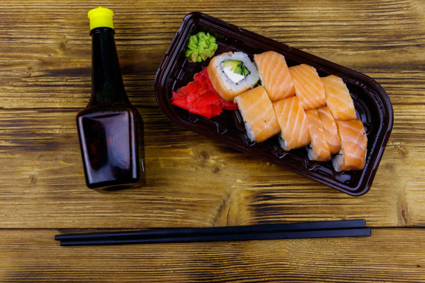 寿司卷费城在塑料盒在木桌上。前视图。装在塑料容器内的寿司供外卖或运送图片下载