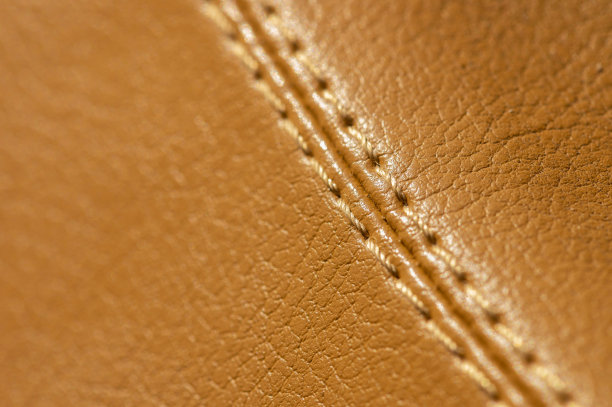 米黄色人造皮革缝合在汽车内部的特写。内饰舒适的背景图片下载