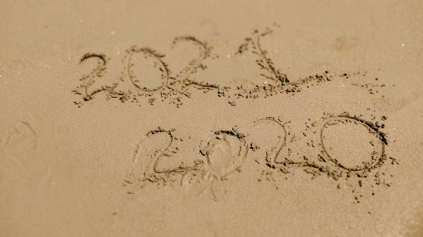 在沙滩上手写的2020和2021年。图片下载