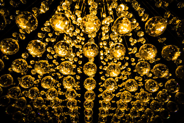 抽象背景-圣诞节装饰或水晶吊灯吊坠或水晶多面体球在黑色的金色调。图片下载