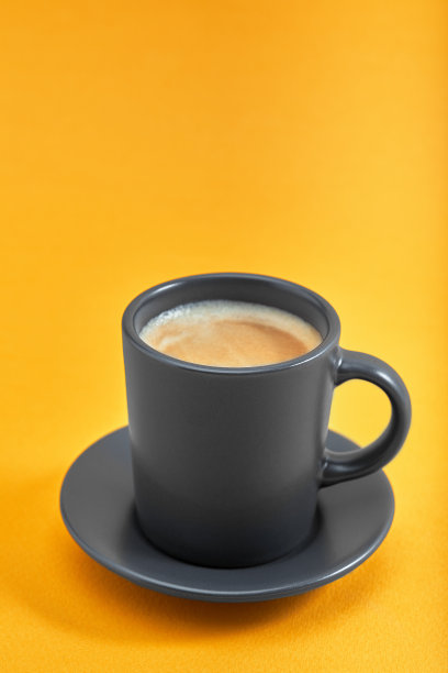 黄色背景上的一杯黑咖啡。概念:早上好，能量提升，动力十足。空间的文本图片下载