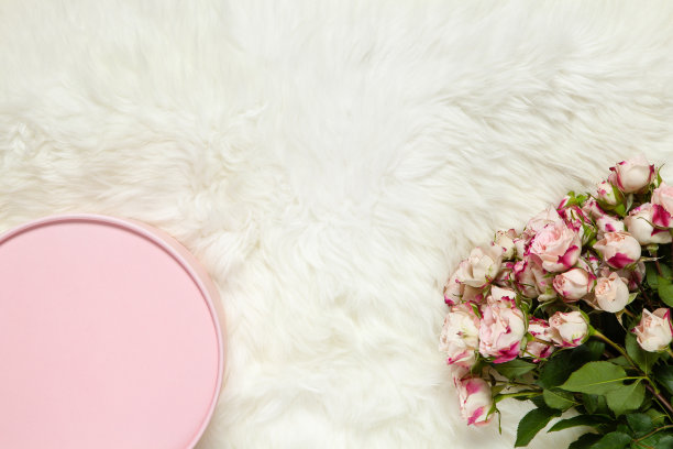 一束小玫瑰，牛奶白色的毛地毯上的礼盒。背景与复制空间，平lay。前视图。3月8日、2月14日、生日、情人节、母亲节、妇女节庆祝概念图片下载