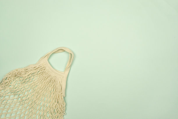 一个白色的网袋躺在浅蓝色的背景上。副本的空间。可重用的事物的概念图片下载