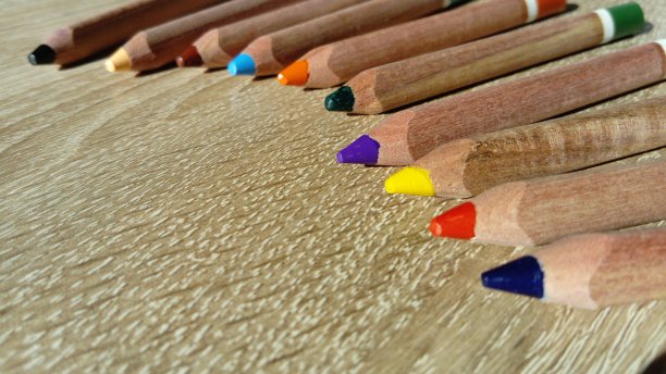 铅笔放在一张木桌上。三角形的木制铅笔是为了发展孩子的手的精细运动技能。图片下载