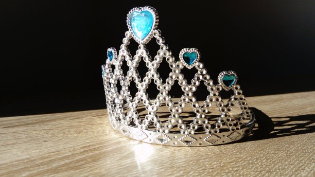 镶有蓝色宝石的皇冠在侧面照明中闪闪发光图片下载