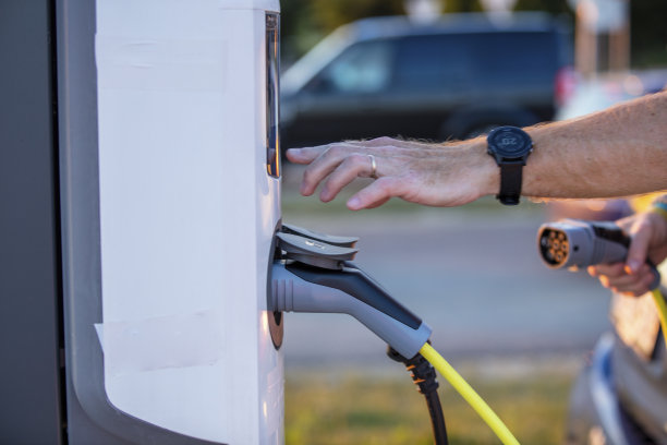 一个人在车站给他的电动车充电图片下载