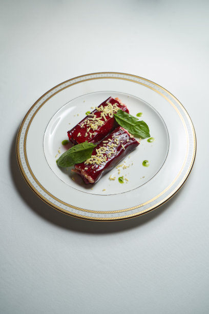 健康沙拉卷甜菜根和鲱鱼在白色盘子。图片下载