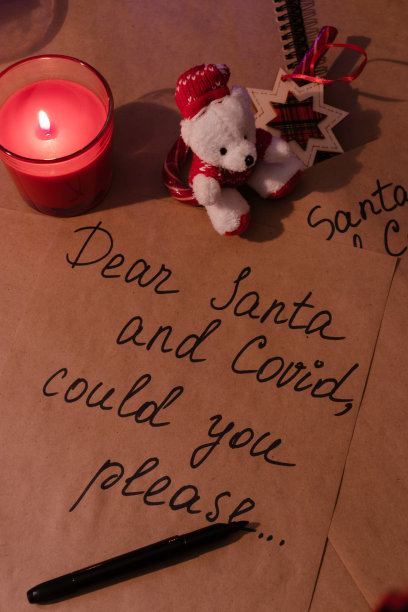 写给圣诞老人和Covid-19圣诞祝福信的夜晚笔迹。在牛皮纸上写有新年和圣诞节的细节和元素。新常态而新冠肺炎。图片下载
