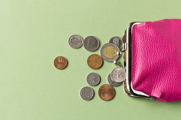 钱包上有硬币，背景很亮。关闭了。有选择性的重点。贫穷的概念。图片下载