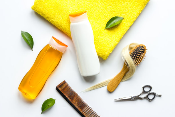 平铺理发师剪刀与锁的金发梳子和护理产品图片下载