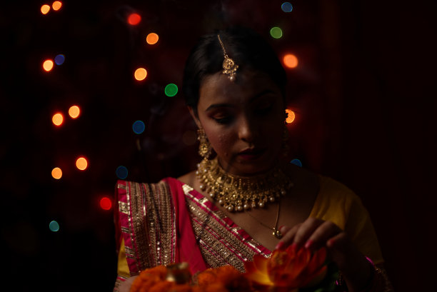 在排灯节的晚上，一个印度孟加拉美丽的黑发女人在五颜六色的光bokeh背景创造的小链灯的肖像。图片下载