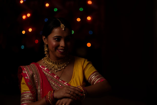 在排灯节的晚上，一个印度孟加拉美丽的黑发女人在五颜六色的光bokeh背景创造的小链灯的肖像。图片下载