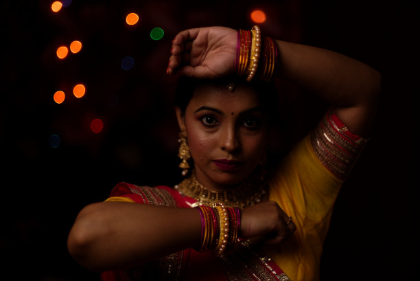 在排灯节的晚上，一个印度孟加拉美丽的黑发女人在五颜六色的光bokeh背景创造的小链灯的肖像。图片下载