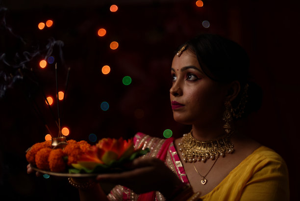 在排灯节的晚上，一个印度孟加拉美丽的黑发女人在五颜六色的光bokeh背景创造的小链灯的肖像。图片下载