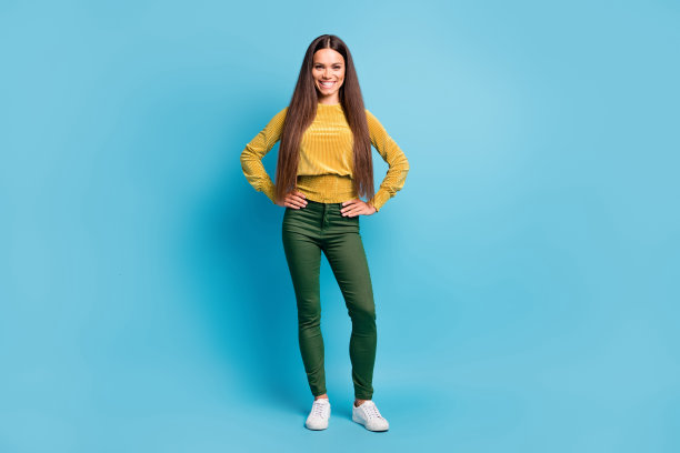 照片肖像女人全身视图与双手在腰部孤立在柔和的蓝色背景图片下载