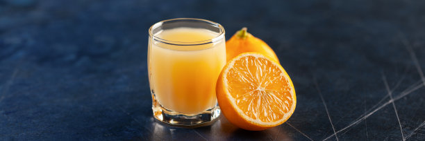 柠檬酒杯，意大利甜柠檬利口酒，传统的烈性酒精饮料，蓝色背景的柠檬。图片下载