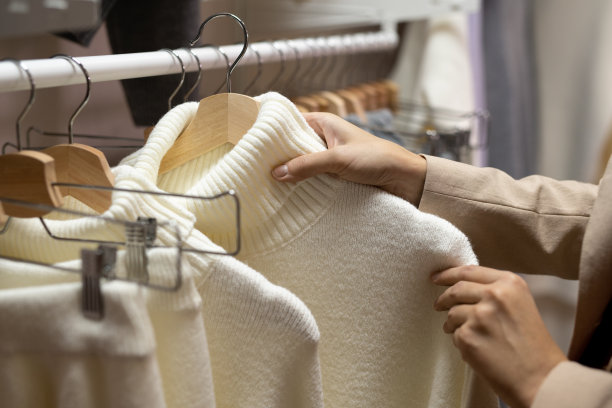 年轻女顾客的手在看新的休闲服装的分类图片下载