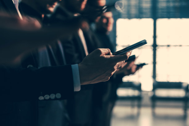 关闭了。一群拿着智能手机的年轻商人的图片图片下载