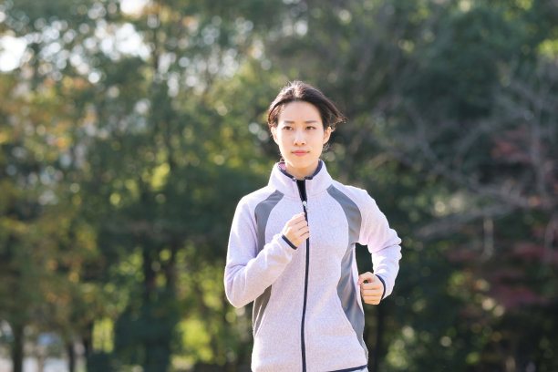 年轻女子在秋天公园慢跑图片下载