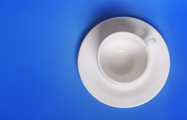 空的白色杯碟上的蓝色背景与一份空间图片下载