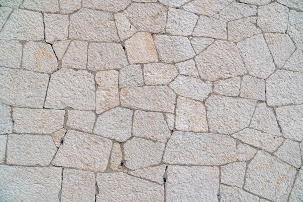 在建筑物正面作为背景或背景的装饰性石灰石。石墙纹理背景。砖砌或石砌地板，室内岩石图案干净，格子砖堆放不均匀图片下载