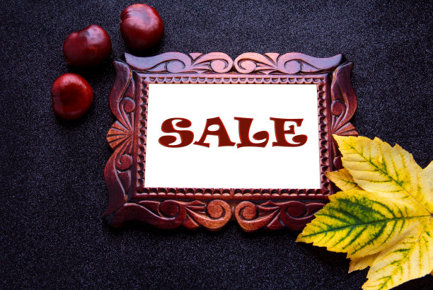 木框与题字出售在黑色的背景与秋叶。图片下载