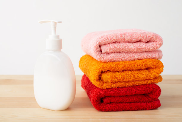 新的鲜艳的毛巾和肥皂在桌子上的白色背景图片下载