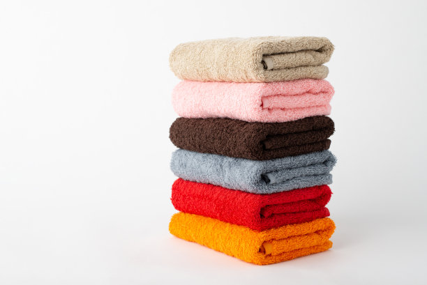 在灰色背景上堆叠不同颜色的毛巾图片下载