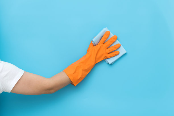 女人用抹布手工清洗蓝色的墙壁图片下载