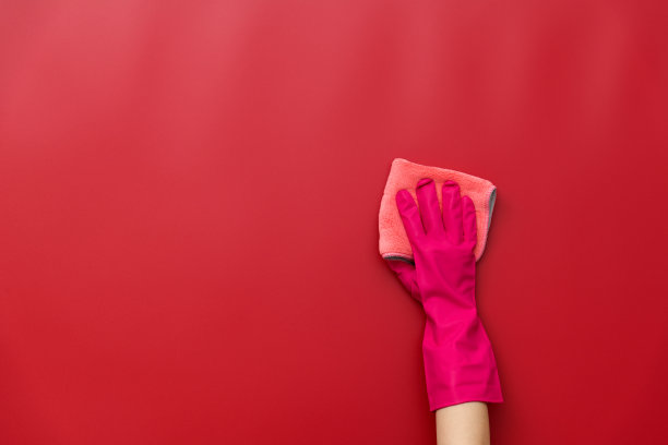 女人用抹布擦着红墙图片下载