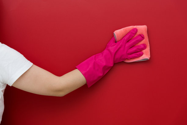 女人用抹布擦着红墙图片下载