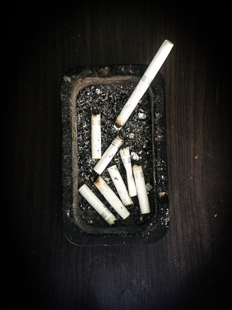 在桌上的烟灰缸里燃烧着香烟图片下载