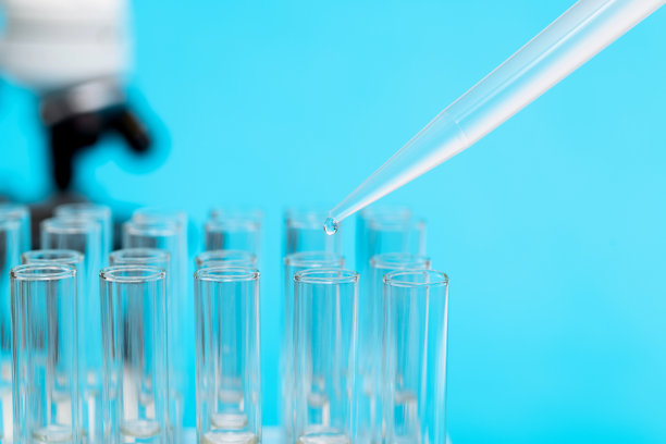 液体滴到蓝色背景的试管中图片下载