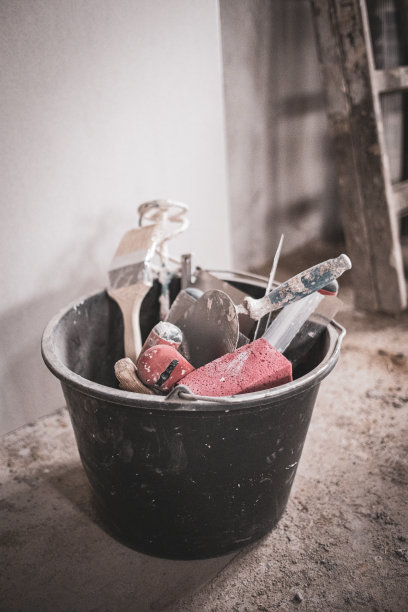 一个装满工具的黑桶立在建筑工地上图片下载