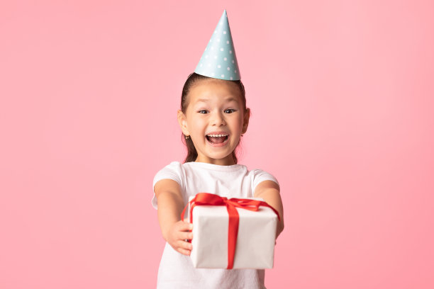 快乐的亚洲女孩在粉色工作室送你礼盒图片下载