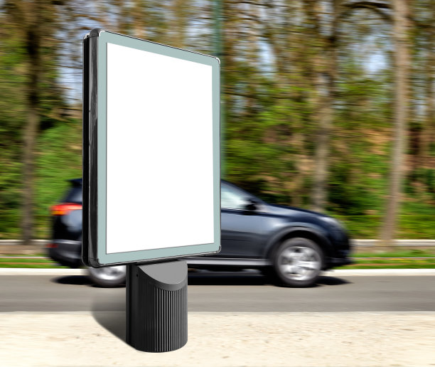 垂直的城市广告牌，反对汽车在森林道路运动图片下载