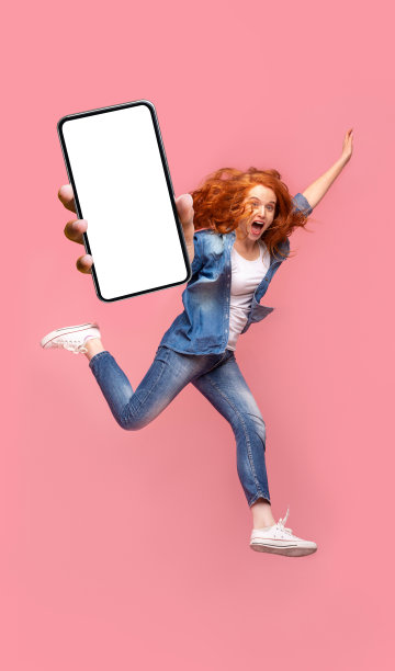 积极的红发女孩跳过粉红色的工作室背景图片下载